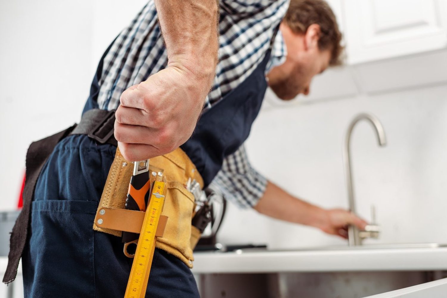 Calgary plumber fitting a pipe under a sink
